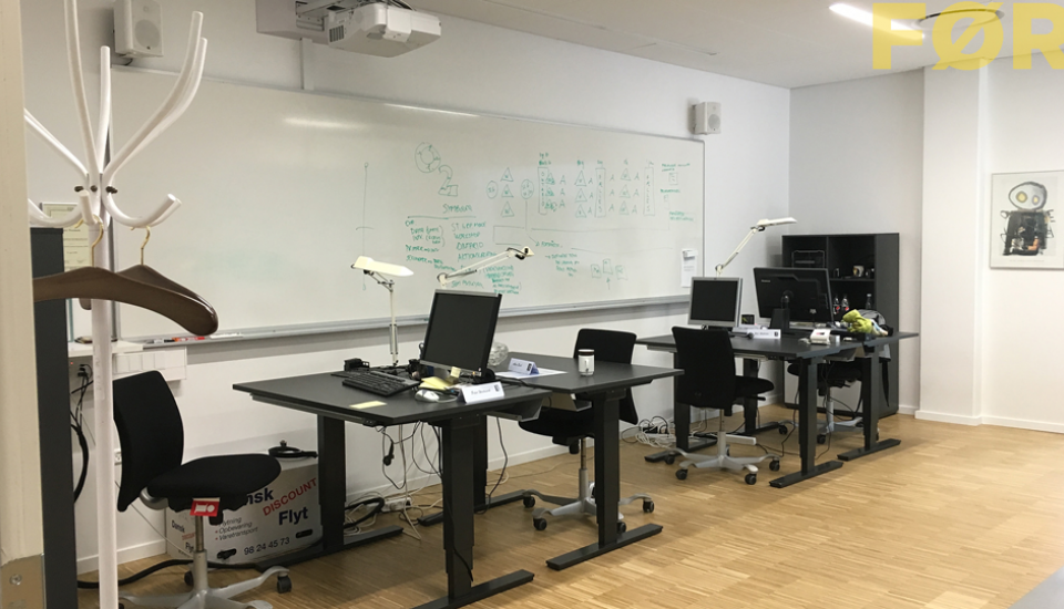 Møbleringen og funktionerne spænder ben for hinanden, whiteboardtavlen er gemt bag arbejdsbordene